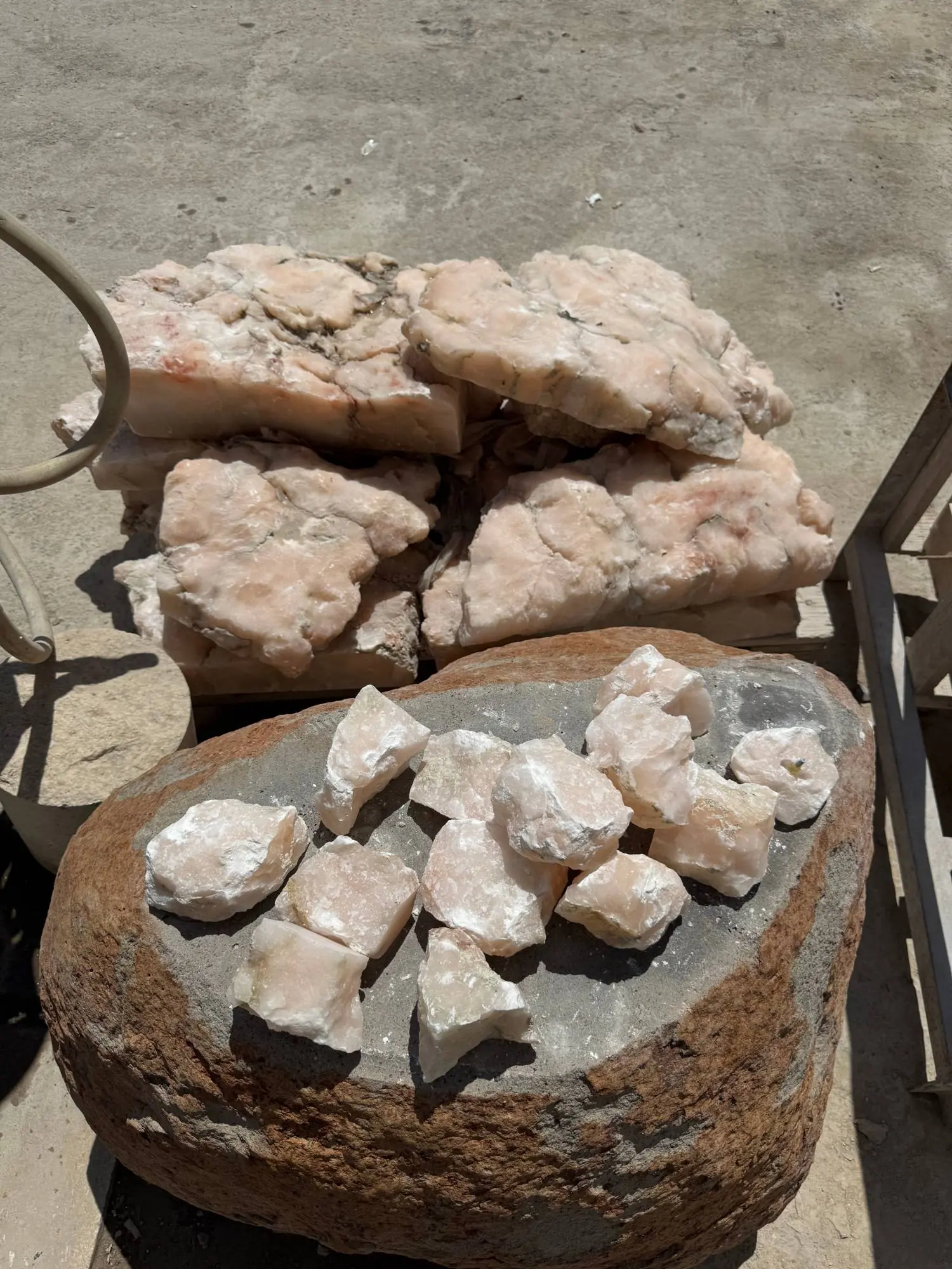 Raw blocks and hand-broken pieces of pink onyx in the workshop